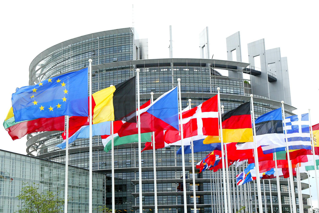 European Union flags in front of the EU Parliament, symbolizing the agreement to tighten regulations for safer and cleaner vehicles, supported by Opus RSE.
